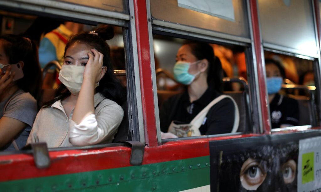 Usuários de ônibus usam máscara contra o coronavírus
